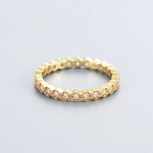 Close-up of gold geometric eternity ring featuring hexagonal frames with round zircons