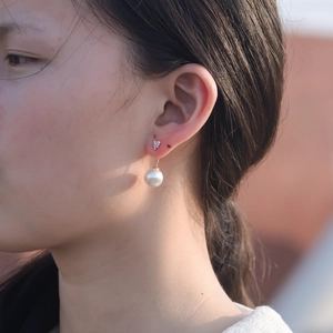 Gros plan sur boucle d'oreille cœur en argent S925 avec zircon et perle pendante