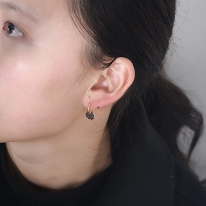 Macro view of S925 silver irregular oval pendant earrings with black pave-set stones