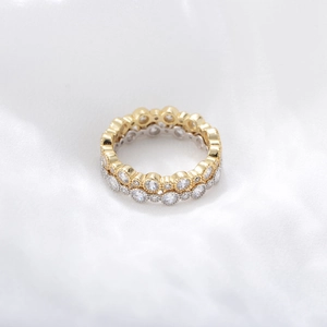 Close-up of stacked gold and silver wave rings with round zircon stones on silk