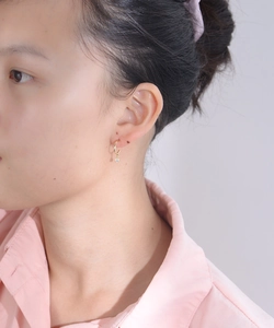 Close-up of elegant gold plated hoop earring with round sparkling zircon on model