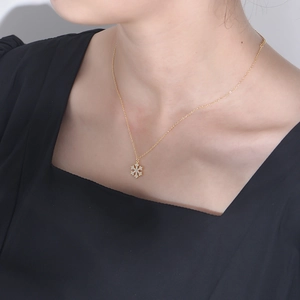 Macro detail of gold snowflake pendant necklace with sparkling cubic zirconia on a model