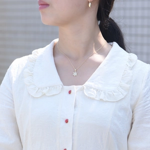 Close-up of a gold S925 snowflake pendant necklace with cubic zirconia on a model