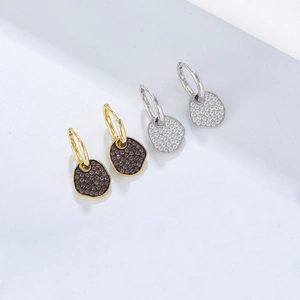 Close-up of S925 silver stamp on gold and silver irregular geometric drop earrings