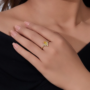 Close-up of a pear-cut yellow zircon crown ring on hand with a gold-plated setting