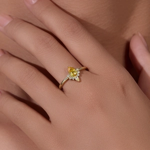 Elegant 18K gold ring with pear-cut yellow zircon and flower-shaped diamond accents