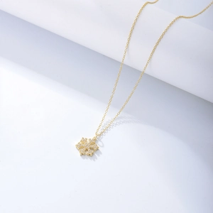 Close-up of golden S925 sterling silver snowflake necklace with sparkling zircon crystals