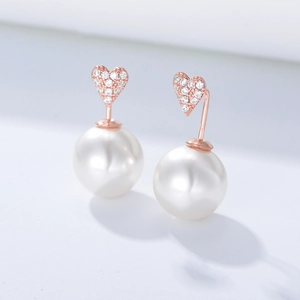Détails de boucles d'oreilles cœur en or rose avec zircons et grandes perles blanches