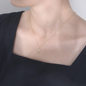 Close-up of a gold S925 silver key pendant necklace with sparkling zircon pavé on a model