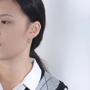 Minimalist gold dinosaur charm hoop earrings for women on a model for daily wear