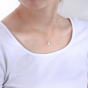 Close-up of a delicate gold S925 sterling silver necklace with a square zircon pendant on neck