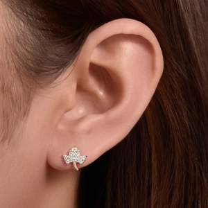 Golden leaf stud earring with crystal paving shown on ear in a close-up profile view