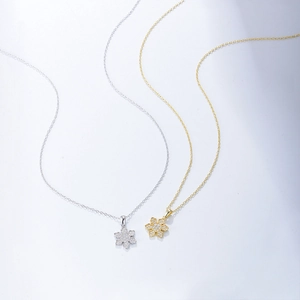 Close-up of gold and silver snowflake pendants featuring sparkling cubic zirconia stones