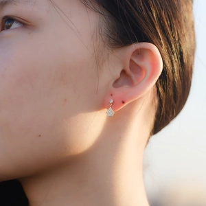 Close-up of elegant gold geometric pentagon earrings with cubic zirconia on model