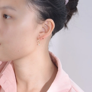 Elegant s925 silver gold-plated stud earrings with single zircon drop on a model