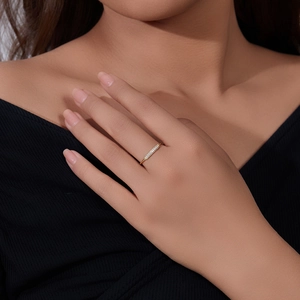 Close-up of a minimalist gold ring with micro-pave cubic zirconia on a model's finger