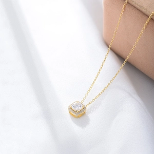 Close-up of a square zircon pendant necklace on a pink velvet jewelry box