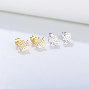 Detailed view of silver and gold maple leaf stud earrings with pavé set zircon stones