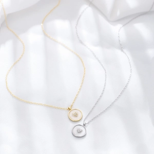 Close-up of S925 sterling silver necklaces with heart zircon in round enamel pendants