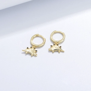 Macro detail of gold dinosaur hoop earrings with black gemstone back accents