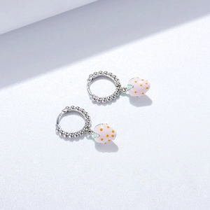 Détail de créoles perlées en argent s925 avec pendentifs fraises en émail rose