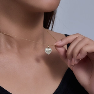 Gros plan d'un collier pendentif cœur en nacre blanche avec pavage de zircons
