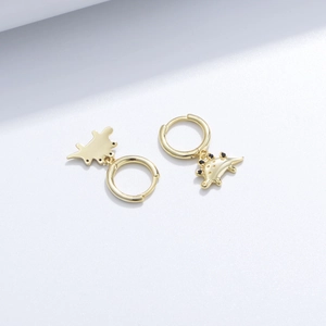 Detailed close-up of golden dinosaur earrings with tiny black zircon stone accents
