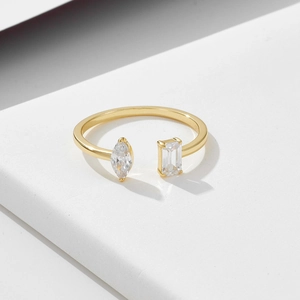 Minimalist gold open ring with marquise and emerald cut zircon stones on white stone base