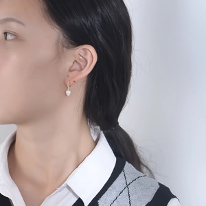 Boucles d'oreilles fraises en argent S925 et émail portées par un mannequin sur fond gris