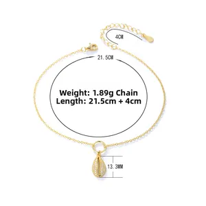 Close-up of golden shell charm with white zircons on chain with lobster clasp detail