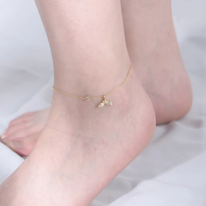 Detail of elegant gold mermaid tail anklet with shimmering crystals on a model foot