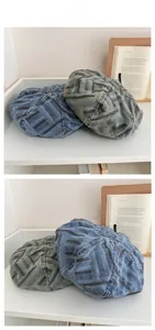 Close-up of vintage striped denim berets in blue and grey-green on a display shelf