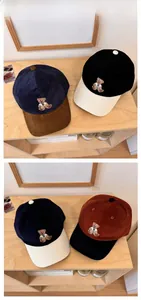 Close-up of color-block corduroy baseball caps featuring cute bear embroidery and textures