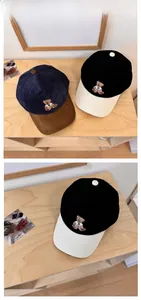 Detailed view of bear embroidery and corduroy texture on two-tone baseball caps