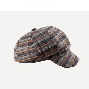 Detail of retro plaid newsboy cap showing yellow and blue wool texture and visor
