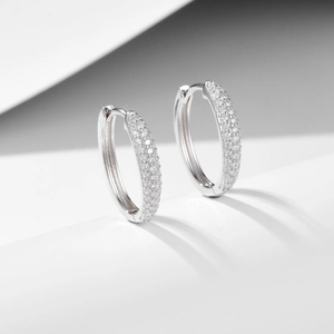 Minimalist 925 sterling silver huggie earrings with pave cubic zirconia on white background