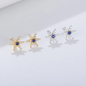 Macro detail of hexagonal star silver studs with blue center stone and pave zircon