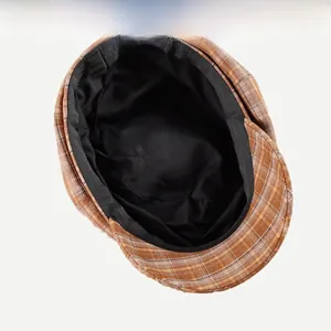 Detailed interior of vintage plaid newsboy cap showing black lining and sweatband