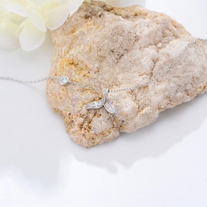 Detailed view of silver mermaid tail anklet with sparkling zircon stones and a single diamond