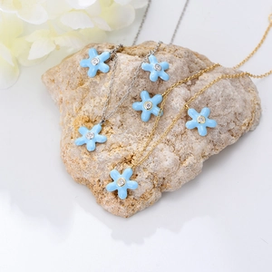 Bohemian light blue flower necklace and earring set on natural stone background