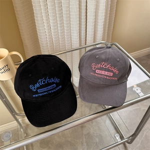 Classic black and grey embroidered cotton baseball caps on a minimalist display stand
