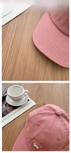 Gros plan sur la casquette rose avec broderie de chat et détails de couture fins
