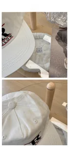 Detail of white cotton baseball cap showing red 3D embroidery and twill fabric texture