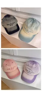 Detail of vintage washed cotton baseball caps with embroidered letters and gradient colors