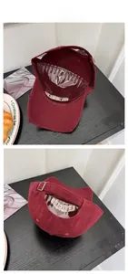 Close-up of vintage burgundy baseball cap with distressed brim and metal buckle strap