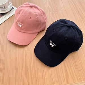 Casquettes de baseball rose et marine avec broderie chat et texte IT'S A CAT sur table