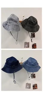 Flat lay of denim bucket hats in four washed colors with adjustable chin straps