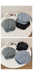 Détail de casquettes gavroche en jean vieilli aux teintes bleues et noires délavées