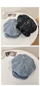 Détail de casquettes gavroche en denim vieilli en bleu clair et gris avec texture déchirée