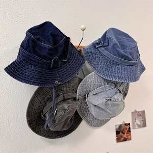 Outdoor denim sun hat with adjustable chin strap shown in four washed colors on a wall